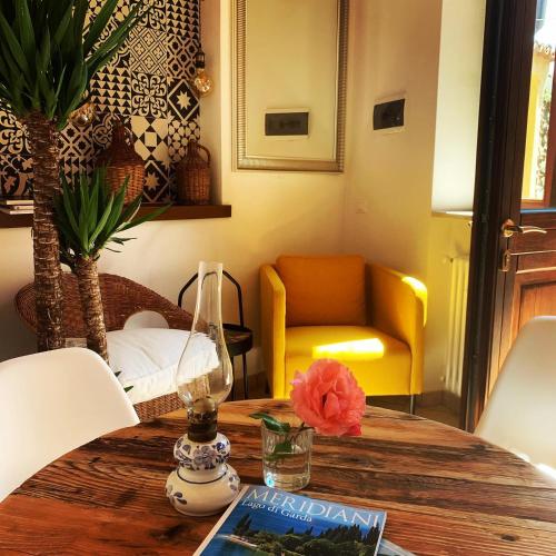 a living room with a table and a yellow chair at FONTANE APARTMENTS in Salò