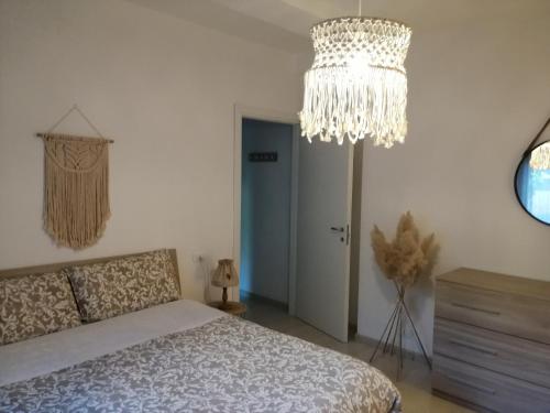 sypialnia z łóżkiem i żyrandolem w obiekcie Shabby house Donatella w mieście Carenno
