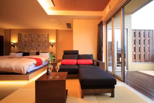 a bedroom with a bed and a couch and a table at Tensui Saryo in Hakone