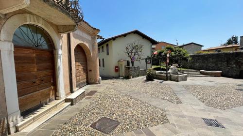 a house with a wooden door and a courtyard at FONTANE APARTMENTS in Salò