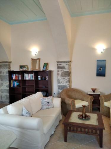 Una sala de estar con un sofá blanco y una mesa. en Apartment Gialos, en Symi