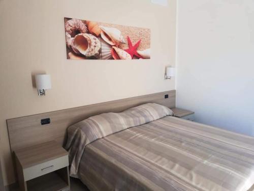 a bedroom with a bed and a painting on the wall at Stella marina in Palinuro