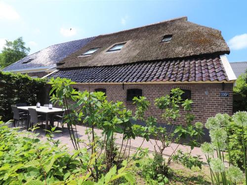 Modern Saxon farmhouse in Dalerveen village في Dalerveen: منزل بطاولة وسقف