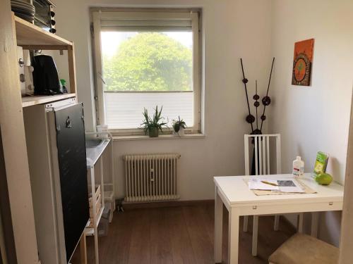 um pequeno quarto com uma mesa e uma janela em Lighthaus Apartment em Graz