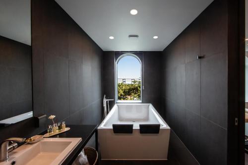 La salle de bains est pourvue d'une baignoire, d'un lavabo et d'une fenêtre. dans l'établissement AG405 Hotel, à Busan