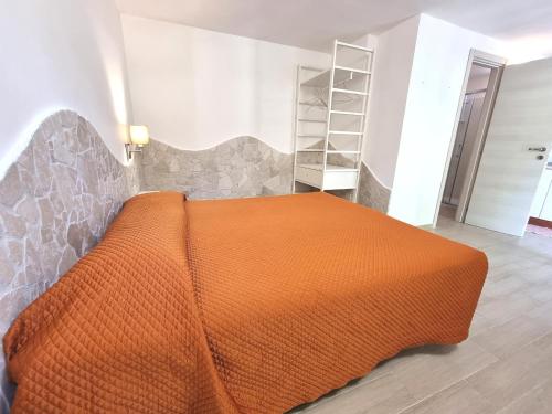 Cette chambre comprend un lit avec un couvre-lit orange. dans l'établissement I Sapori Del Gargano, à Vieste