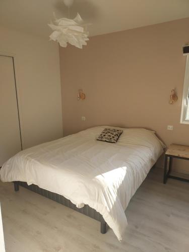 Un dormitorio con una cama con una manta. en Maison avec piscine chauffée, en Renac