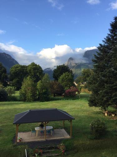 un cenador con una mesa de picnic en un campo en Maison Laclede, en Bedous