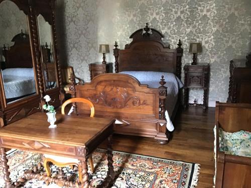 een slaapkamer met een houten bed en een houten tafel bij Maison Laclede in Bedous
