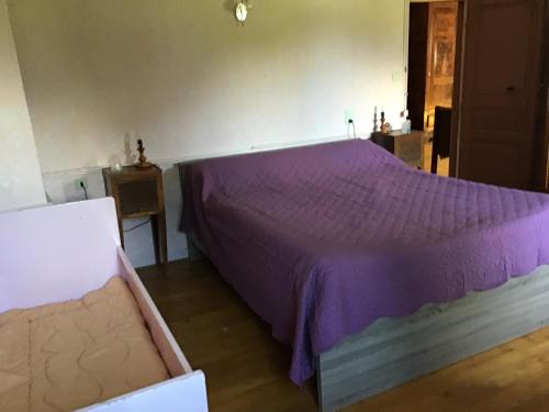 um quarto com uma cama com uma colcha roxa em Maison Laclede em Bedous