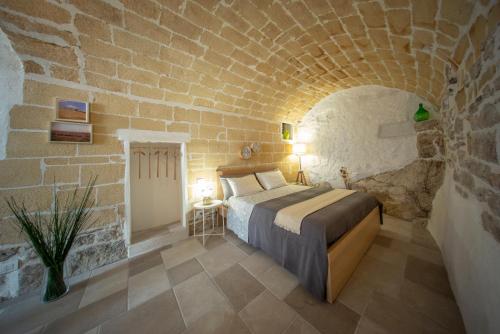 um quarto com uma cama numa parede de tijolos em La Ferula Magica - alloggio tipico em Minervino Murge