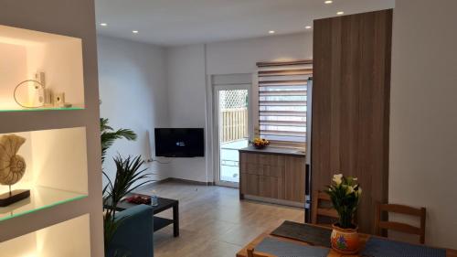 a living room with a table and a television at 'Aegean Breeze' Lux & Cozy Apartment in Nea Makri in Nea Makri