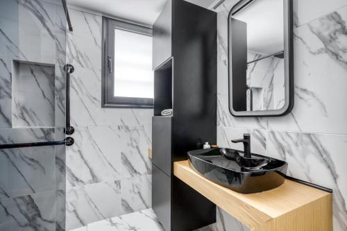 łazienka z czarną umywalką i lustrem w obiekcie Spacious flat with courtyard in Peristeri! w Atenach