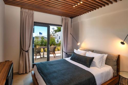 a bedroom with a large bed and a balcony at Uma Ray Suites in Fira