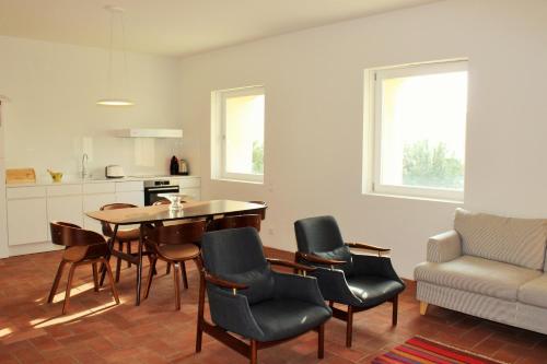 a living room with a table and chairs and a couch at Convento Bernardas duplex BL - 3 bedroom in Tavira