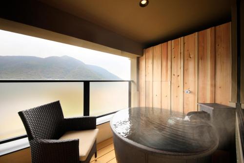 a room with a table and chairs and a large window at Tensui Saryo in Hakone