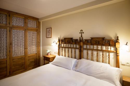 um quarto com uma cama grande e uma cabeceira em madeira em Wood ✪ WiFi, terraza ✪ Ideal excursiones em Formigal