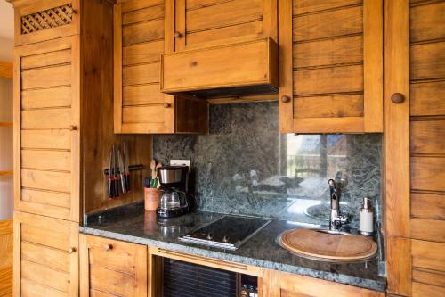 una cocina con fregadero y armarios de madera en Wood ✪ WiFi, terraza ✪ Ideal excursiones, en Formigal