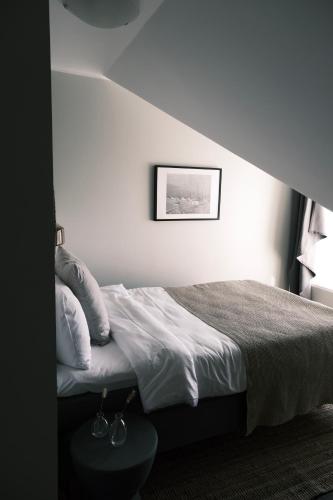 a bed in a room with a white wall at Skärgårdshotellet Hönö in Hönö