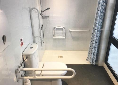 a small bathroom with a toilet and a shower at Ten To Go Hostel in Barcelona