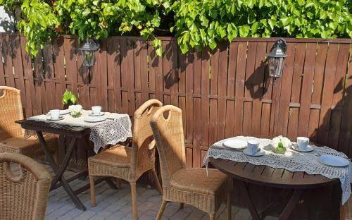 a patio with two tables and chairs and a fence at Babie Lato b&b in Uniejow