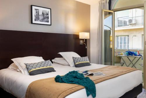 Postel nebo postele na pokoji v ubytování Hôtel Locarno Nice