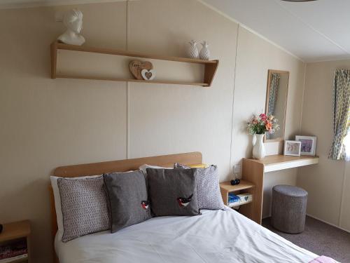 a bedroom with a bed with pillows on it at pool-garden-2br-parking-wifi-sleeps6 in Paignton