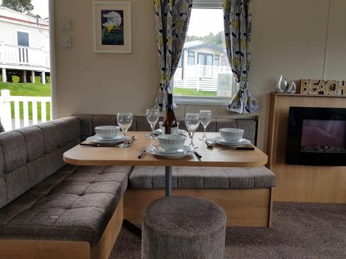 a table with wine glasses and a couch at pool-garden-2br-parking-wifi-sleeps6 in Paignton
