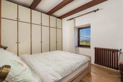a bedroom with a bed and a window at House Obrš in Mošćenička Draga