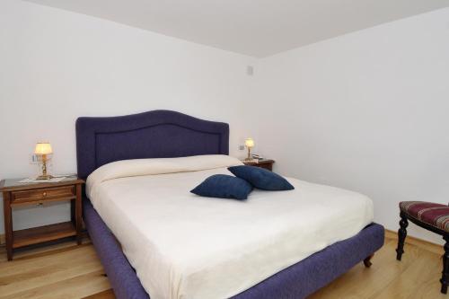 a bedroom with a blue bed with two pillows on it at Boutique Gimagì in Amalfi