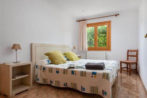 una camera con un letto e una sedia e una finestra di Villa Casa Abel with swimming pool a Can Picafort