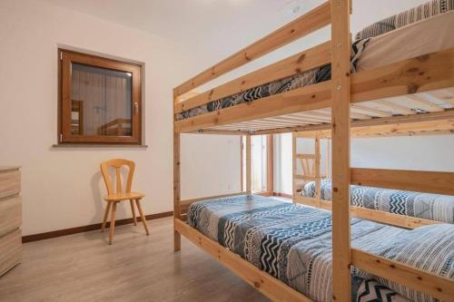 - une chambre avec 2 lits superposés et une chaise dans l'établissement Lovely house in the most peacefull place of Grado, à Grado