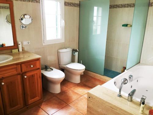 a bathroom with a toilet and a tub and a sink at BINIALMESC in Alaior