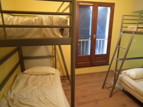 コロミエにあるFriendly Aubergeの窓付きの客室で、二段ベッド2台が備わります。
