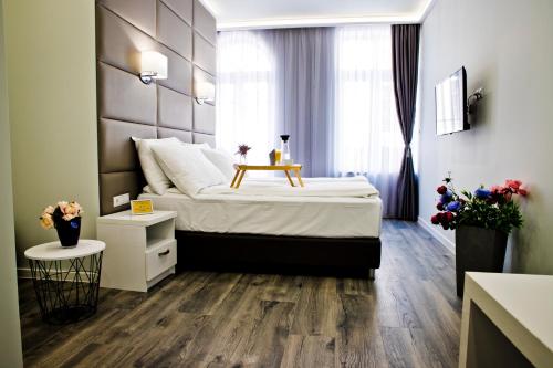 a bedroom with a large bed with a wooden floor at Plovdiv City Center Hotel in Plovdiv