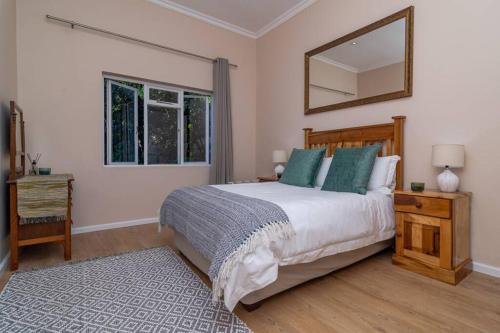 a bedroom with a bed and a mirror on the wall at The Garden on Phantom - "Off the grid" in Knysna
