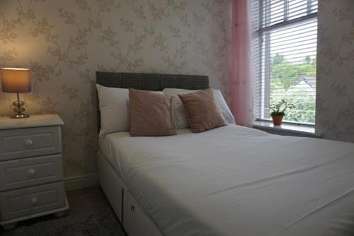 1 dormitorio con cama blanca y ventana en Tirchonaill Townhouse, en Donegal