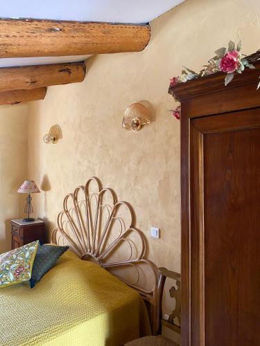 a bedroom with a bed with a wooden head board at Chambres d'hôtes et studios de charme - A Mandria in Murato