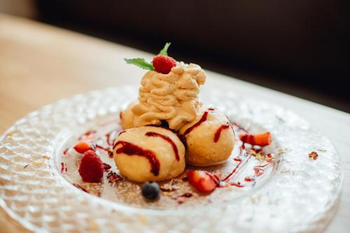 a plate with a dessert with strawberries and ice cream at Boutique Hotel Siglisberg in Štiavnické Bane