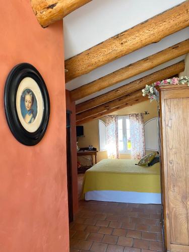 a bedroom with a bed with a picture on the wall at Chambres d'hôtes et studios de charme - A Mandria in Murato