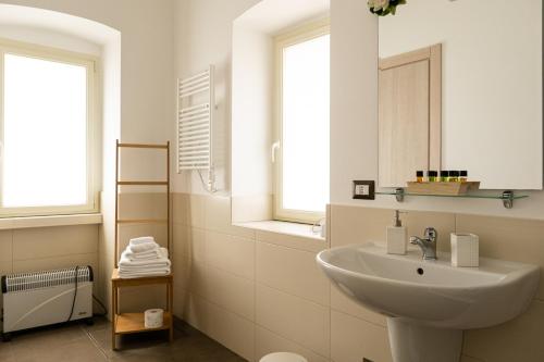 ein weißes Badezimmer mit einem Waschbecken und einem Spiegel in der Unterkunft Nova Domus in Castellaneta