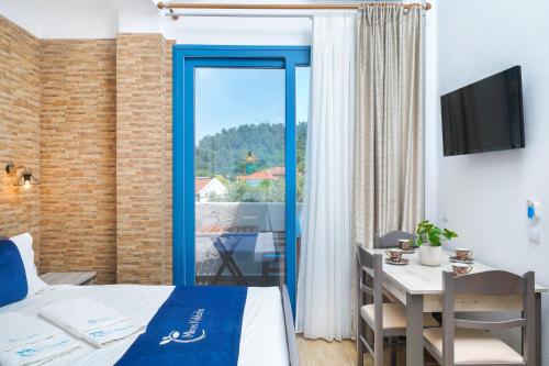 a room with a bed and a table and a window at Mikres Kyklades in Skala Potamias