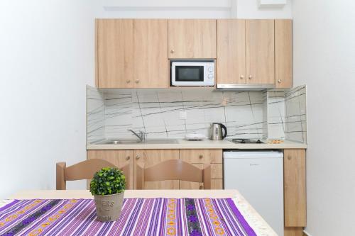 a small kitchen with a table and a microwave at Mikres Kyklades in Skala Potamias