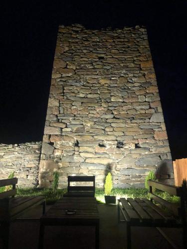 a stone wall with a bench in front of it at Capra Hotel Kazbegi in Stepantsminda