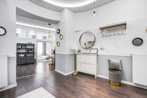 a living room with white walls and a mirror at RP1 Apartment in Budapest