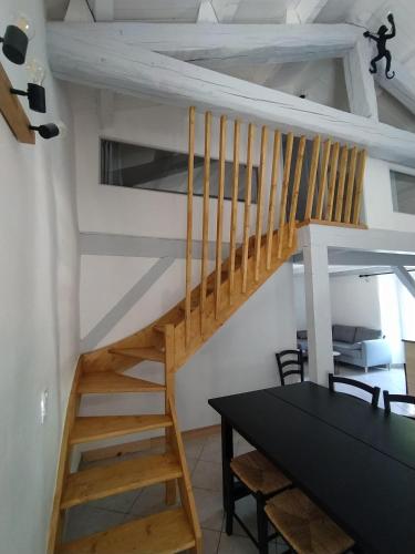 a wooden staircase in a room with a table at La Maison du Chassezac in Les Assions