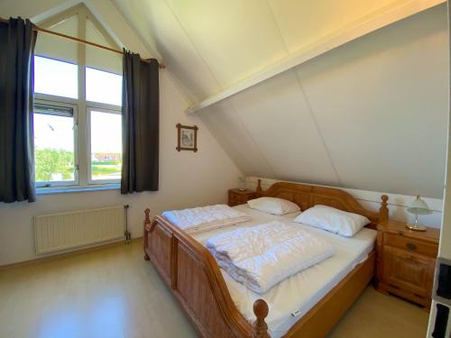 a bedroom with a bed and a large window at Hello Zeeland - Vakantiehuis Zwin 019 in Breskens