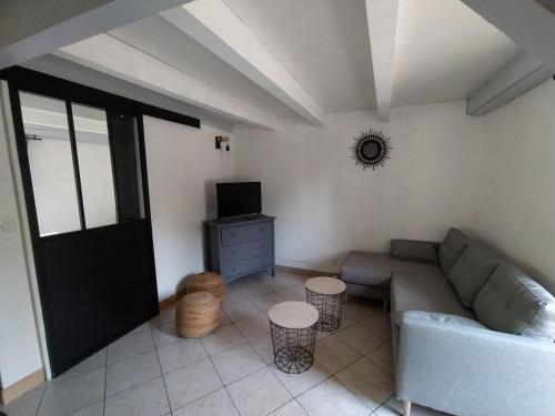 a living room with a couch and a tv at La Maison du Chassezac in Les Assions