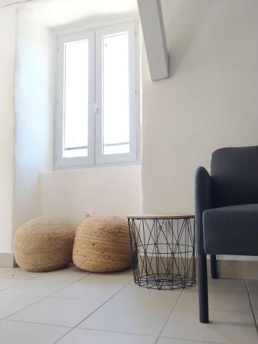 a living room with a chair and two ottoman at La Maison du Chassezac in Les Assions