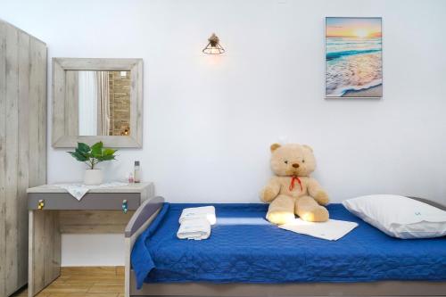 a teddy bear sitting on a bed in a bedroom at Mikres Kyklades in Skala Potamias